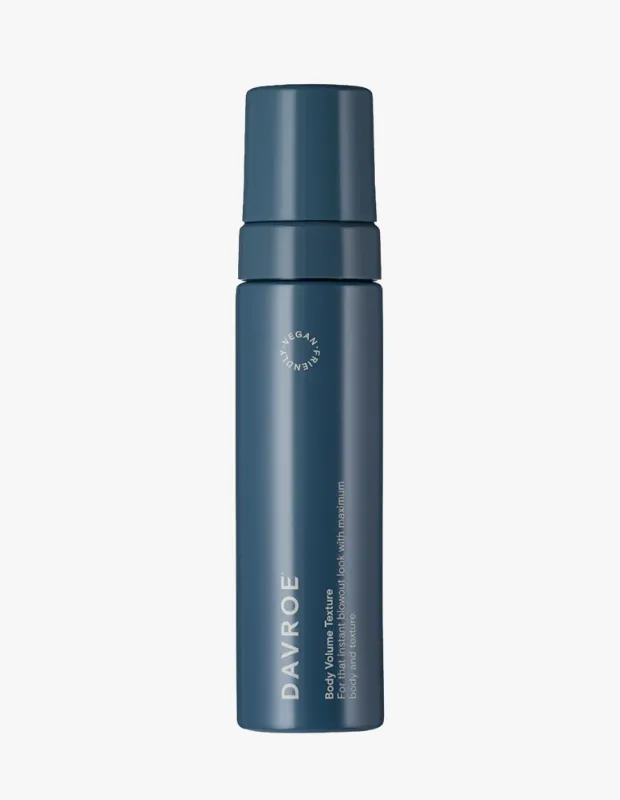 Koyu teal renkli, silindirik tasarımlı, kapaklı Davroe Body Volume Texture saç köpüğü şişesinin görselinde, üzerinde beyaz harflerle DAVROE Body Volume Texture yazısı ile anında fönlü, maksimum dolgunluk ve doku sağlayan bir görünüm vaat eden açıklaması ve VEGAN FRIENDLY logosu belirgin şekilde görülüyor.