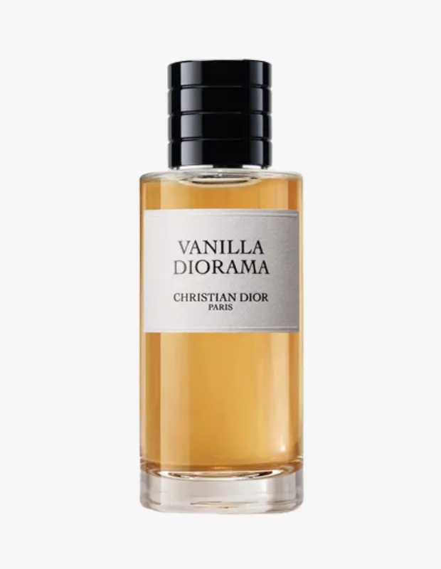 Beyaz arka plan üzerinde yer alan, kehribar rengi sıvıyla dolu, siyah yivli kapaklı ve ön yüzündeki beyaz etikette büyük harflerle Vanilla Diorama, altında ise Christian Dior Paris yazan uzun, şeffaf cam Dior parfüm şişesi.