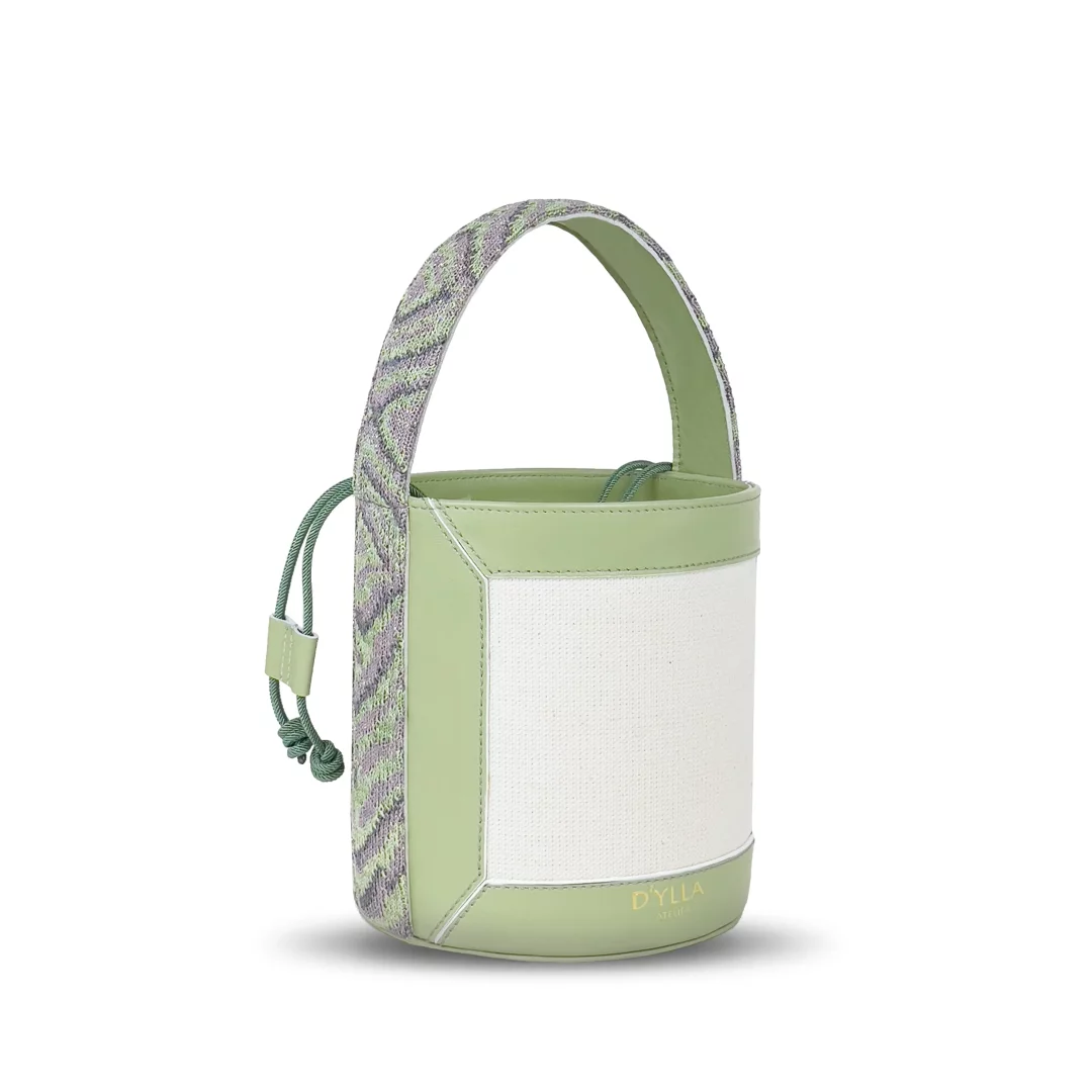 Marka Adı: D'ylla Atelier
Ürün Adı: D'ylla Atelier Kadın Lena Bucket Bag Green
Ürün Cinsiyeti: Kadın
Ürün Tipi: Kova Çanta
Ürün Sezonsallığı: İlkbahar/Yaz
Ürün Çeşidi: El Çantası
Ürün Özellikleri: Bu modern kova çanta, parlak açık yeşil deri görünümlü paneller ve ön yüzündeki krem rengi dokulu tekstil malzeme ile dikkat çekiyor. Çantanın silindirik ve yapılandırılmış formunu tamamlayan tek üst sapı, açık yeşil, mor ve gri tonlarında örme tekstil ile kaplanarak özgün bir dokunuş katıyor. Üst kısmında yer alan açık yeşil büzgülü ip kapatma mekanizması hem pratiklik hem de estetik bir detay sunar. Alt kısmında zarifçe işlenmiş D'ylla Atelier logosu markanın kalitesini vurgular. Yanlarda dikey deri şeritler ve temiz dikiş hatları, çantanın minimalist ancak karakterli tasarımını destekler.
Öne Çıkan Detaylar:
- Canlı açık yeşil ve krem rengi dokulu yüzeylerin modern kombinasyonu
- Açık yeşil, mor ve gri tonlarında özel olarak örülmüş, dokulu üst sap
- Tekstil ve deri malzemelerin uyumlu birleşimiyle zenginleşen yapı
- Şık ve pratik büzgülü ip kapatma sistemi
Kimler Kullanıyor?: Bu çanta, aktif ve dinamik bir stil sahibi olan, görünümünde renkleri ve özgün detayları ön plana çıkarmayı seven bireyler için tasarlanmıştır. El emeği işçiliğine değer veren, kaliteli ve dikkat çekici aksesuarlarla kişisel tarzını yansıtmayı sevenler, bu çantayı hem günlük şıklıklarında hem de özel anlarında neşeli ve modern bir tamamlayıcı olarak kullanabilirler.
