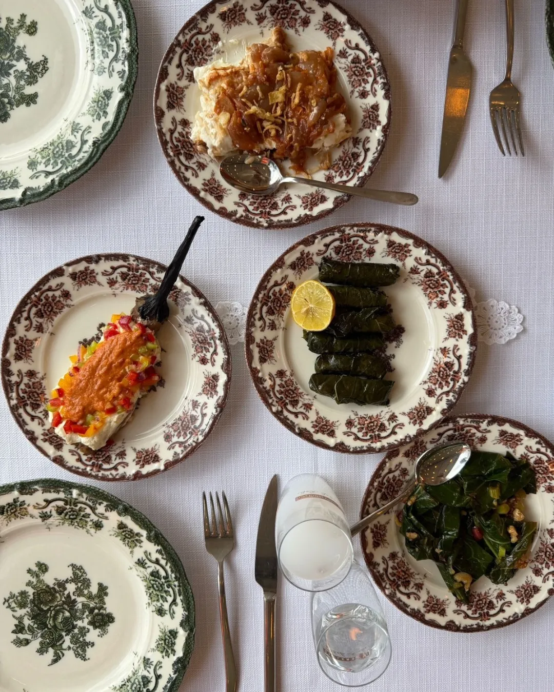 Eski zamanların ruhunu taşıyan, taş duvarlı ve ahşap detaylı bir sokakta, dönemin geleneksel kıyafetlerini giymiş insanların günlük yaşantılarından kesitler sunan, nostaljik ve sıcak bir atmosfer yaratan, geçmişin büyüsünü yansıtan bir an.