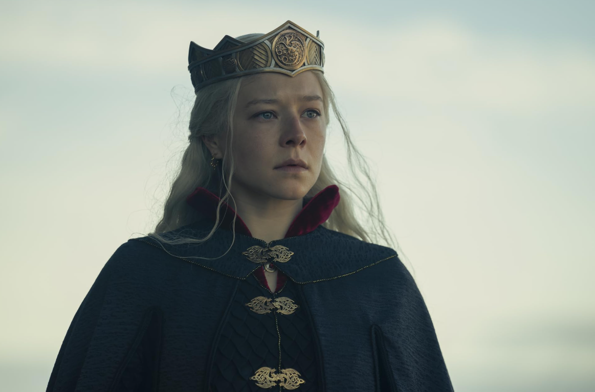 House of the Dragon 3. sezonunda Demir Taht'ın resmi varisi Prenses Rhaenyra Targaryen, işlemeli tacı ve koyu renk peleriniyle göğe bakarken, yüzünde hanedanının ve çocuklarının geleceği için verdiği mücadeleyi yansıtan kararlı ve melankolik bir ifade var.