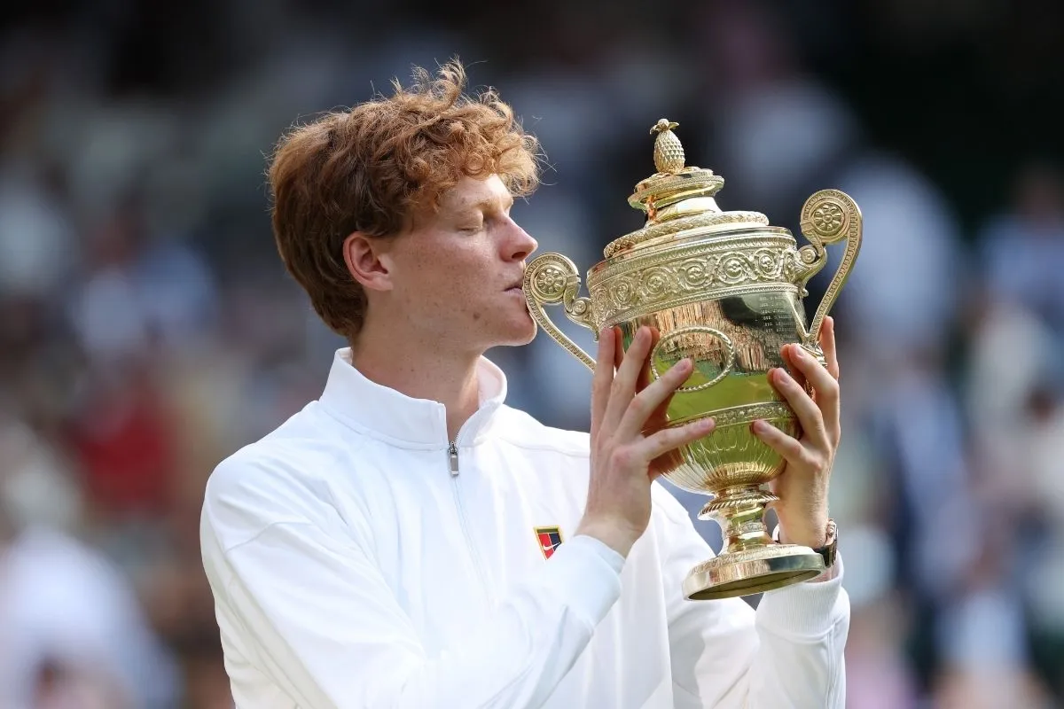 İtalyan tenisçi Jannik Sinner, ikonik Grand Slam kupasını coşkuyla iki eliyle tutarak dudaklarına yaklaştırıp öperken, kariyerindeki zirveye giden yolculuğun ve ATP dünya 1 numarası olma azminin sembolünü kutluyor.