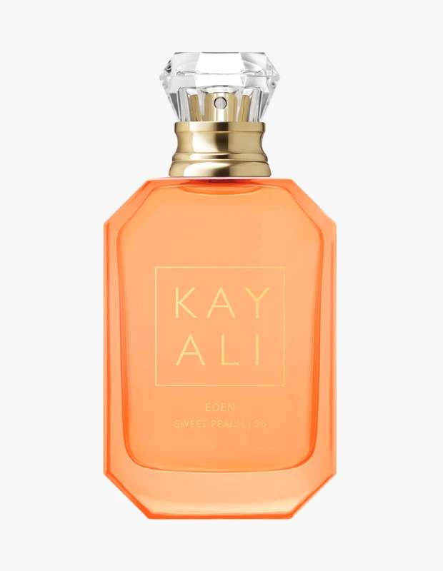 Kayali markasının Eden Sweet Peach parfümü, canlı şeftali rengindeki sekizgen şişesi, parlak kristal kesimli kapağı, altın detaylı boyun kısmı ve üzerinde KAYALI EDEN SWEET PEACH | 35 yazısıyla beyaz zeminde duruyor.
