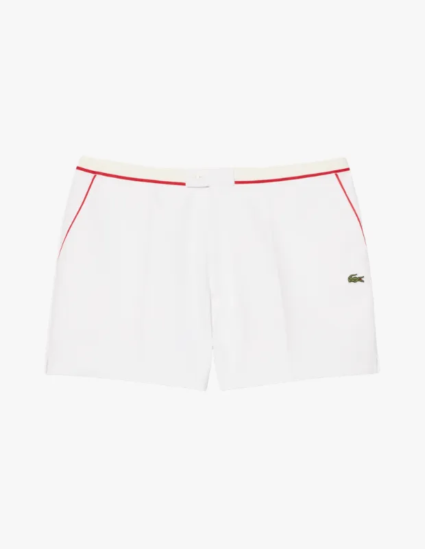 Bu Lacoste erkek regular fit şortu, krem renkli beli ve ceplerini çevreleyen zarif kırmızı biyeleriyle dikkat çeken, sağ paçasında ikonik timsah logosu işlenmiş şık ve sportif beyaz bir modeldir.