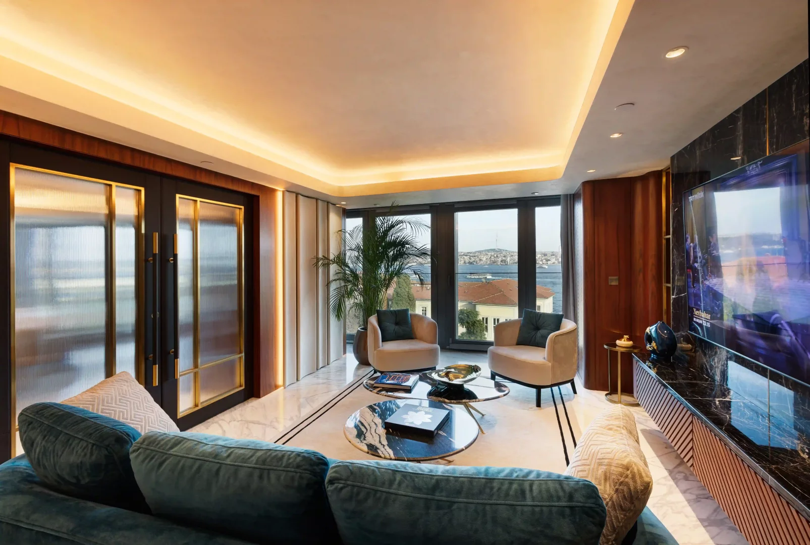 Maestro Hotel'in lüks süitinin geniş pencerelerinden Boğaz'a bakan, modern tasarımlı bu yaşam alanında kadife koltuklar, mermer sehpalar ve duvara monte büyük bir televizyon, sıcak bir ortam aydınlatmasıyla şık bir konfor sunuyor.