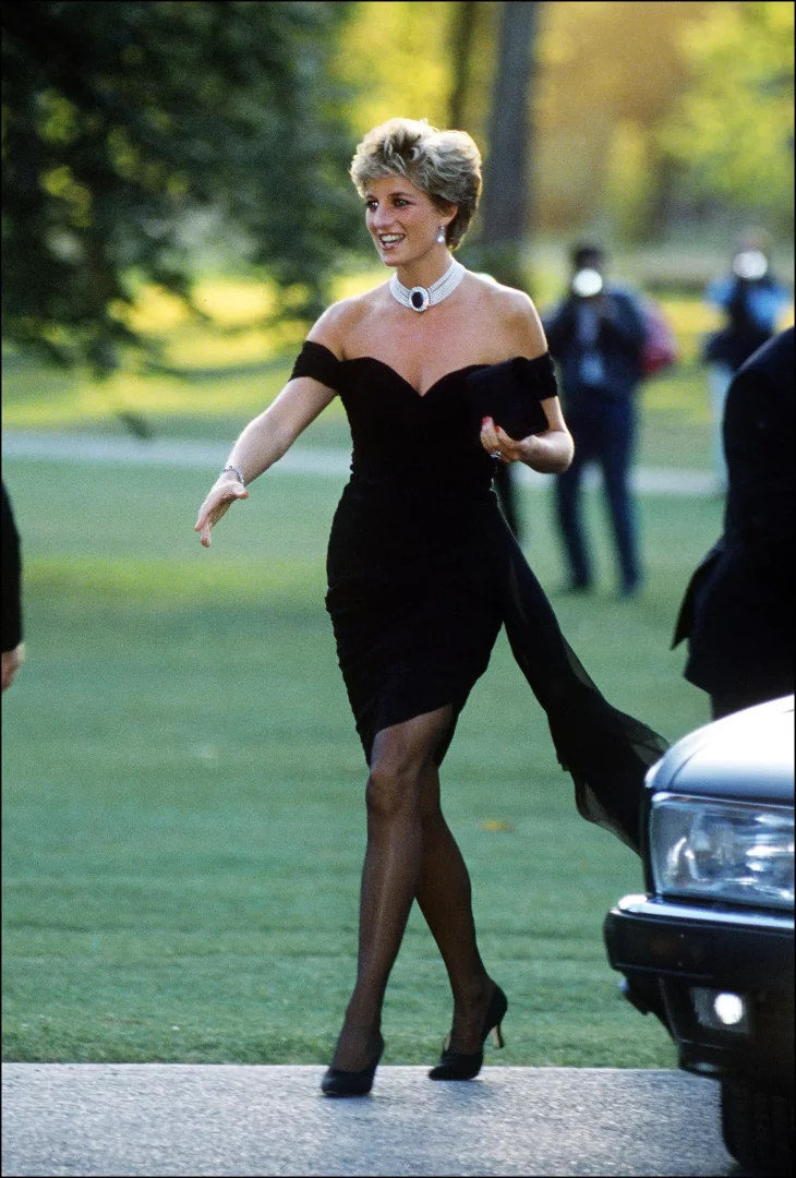 Prenses Diana, kraliyet protokolünü cesurca esneten İntikam Elbisesi olarak anılan omuzları açık, vücuda oturan siyah elbisesi, çok sıralı inci gerdanlığı ve topuklu ayakkabılarıyla kendine güvenli Prenses Diana stilinin en çarpıcı anlarından birini sergiliyor.