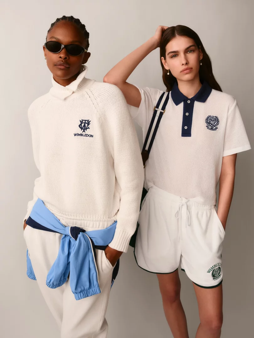 Wimbledon'ın resmi giyim sponsoru Ralph Lauren'in 2026 kapsül koleksiyonundan iki model, biri beyaz balıkçı yaka süveter ve jogger pantolon, diğeri lacivert yakalı polo tişört ve şort giyerek turnuvanın zamansız retro tenis estetiğini ve sessiz lüks stilini yansıtıyor.