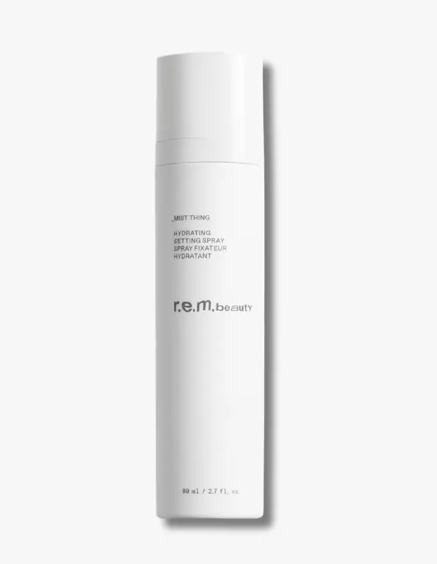 Beyaz bir arka plan üzerinde yer alan, r.e.m. beauty markasına ait, üzerinde Mist Thing yazısı bulunan 80 ml'lik beyaz silindirik nemlendirme ve sabitleme spreyi şişesi, ürünün şık tasarımını ve işlevsel özelliklerini öne çıkarıyor.