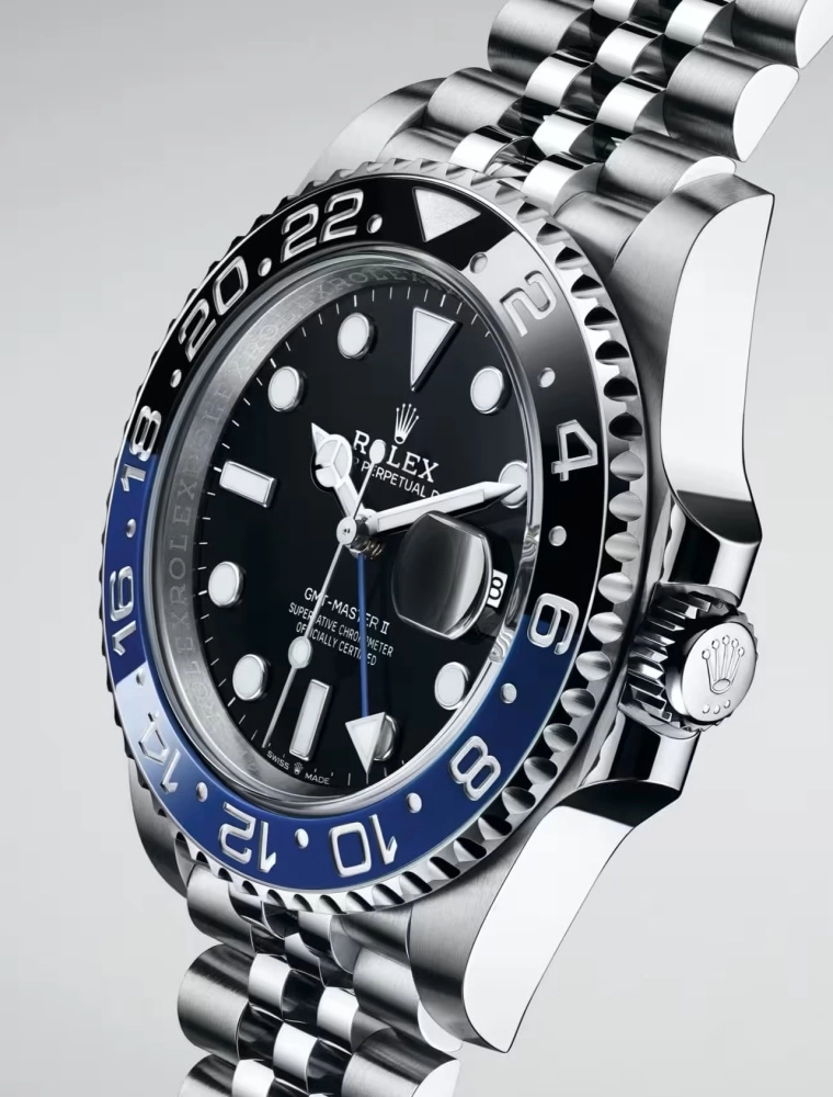 Parlak çelik kasalı, siyah kadranlı, mavi ve siyah iki renkli seramik bezelli ve göz alıcı Jubilee bilezikli bir Rolex GMT-Master II Batman kol saati, tüm detaylarıyla hafif bir açıyla yakın planda sergileniyor.