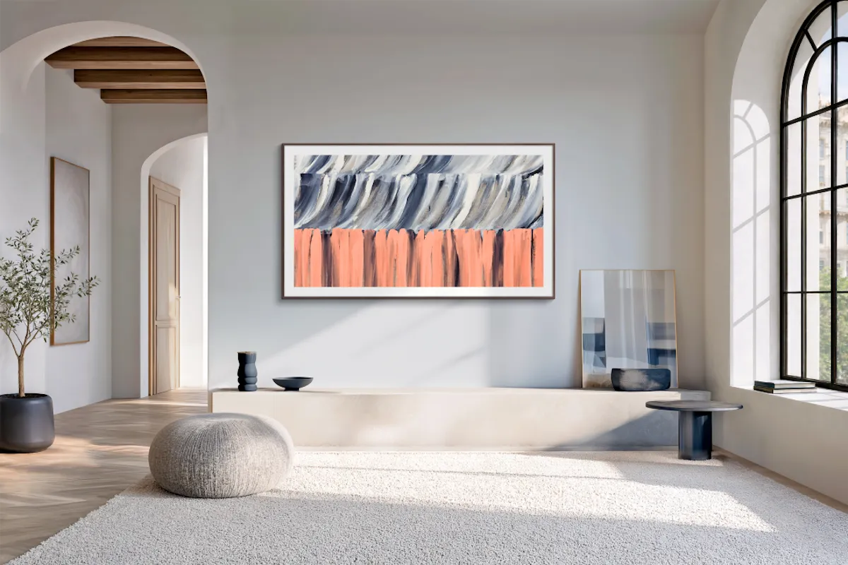 Modern ve minimalist bir oturma odasında, 2026 TV serisinden bir Samsung TV duvara sanat eseri gibi entegre edilmiş, üst kısmı dalgalı gri alt kısmı mercan rengi fırça darbelerinden oluşan soyut bir tablo sergiliyor.