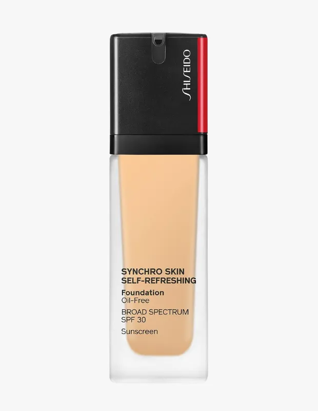 İçinde açık bej renginde Shiseido Synchro Skin Self-Refreshing fondöten bulunan şeffaf, dikdörtgen bir şişe, ürünün yağsız ve SPF 30 güneş korumalı olduğunu belirten yazılarla birlikte, siyah kapağında kırmızı bir şerit ve beyaz Shiseido logosuyla beyaz arka planda dikey olarak konumlanmış.
