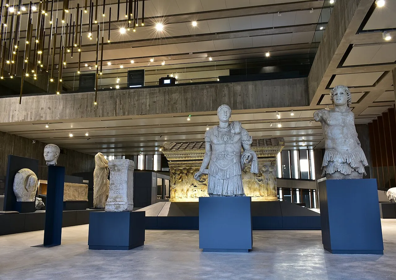 Troya Müzesi'nin geniş ve modern iç mekanında, şık siyah kaideler üzerinde sergilenen çeşitli antik heykeller, büstler ve üzerinde Latince yazılar bulunan tarihi eserler, yüksek tavanlardan sarkan yıldız benzeri aydınlatmalar eşliğinde ziyaretçilere tarih yolculuğu sunuyor.
