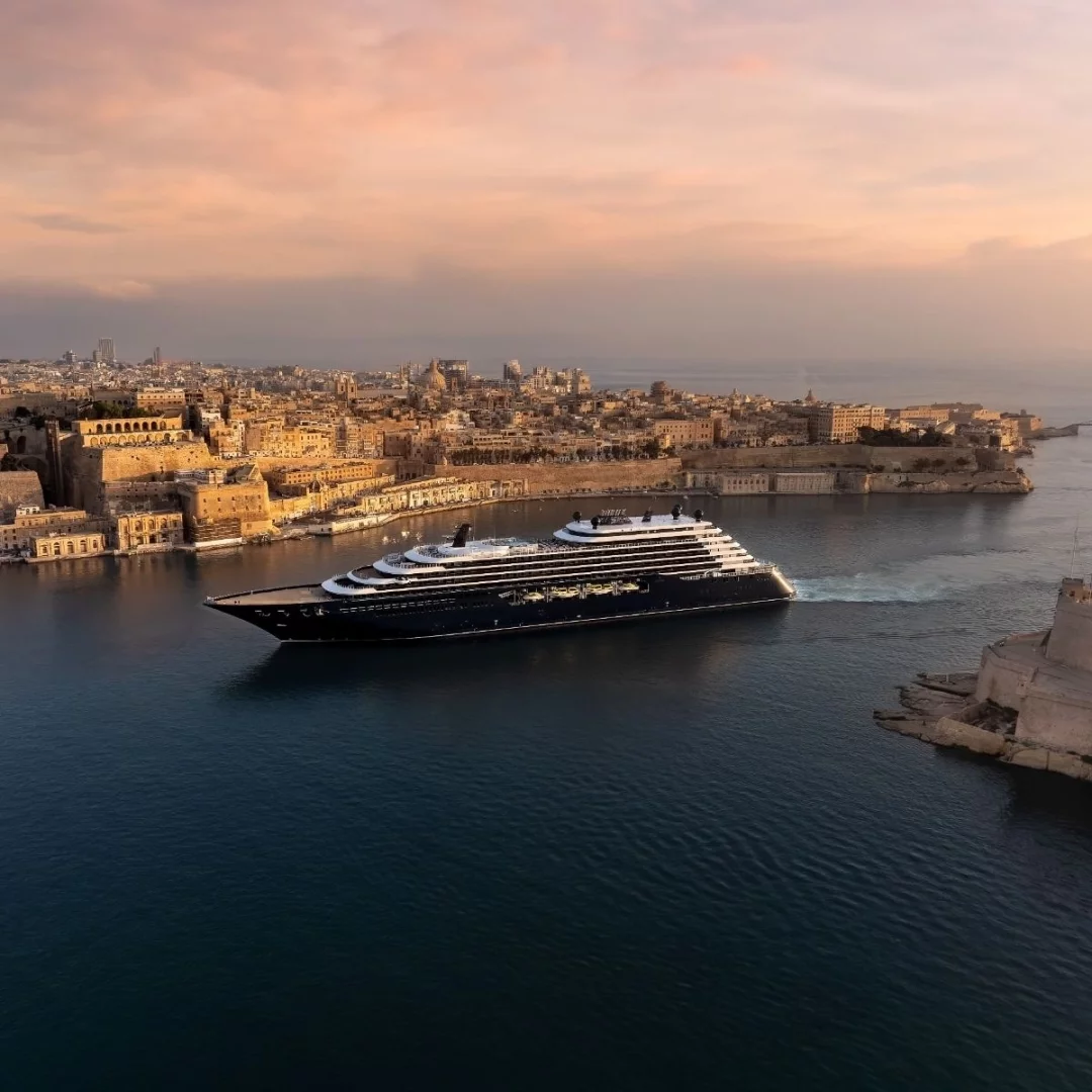 Gün batımının yumuşak ışıkları altında, tarihi bir Akdeniz şehrinin silueti önünde ilerleyen The Ritz-Carlton Yacht Collection Ilma, lüks cruise deneyiminde mahremiyet ve butik hizmet sunan yatlaşma eğiliminin somut bir örneği olarak görünüyor.