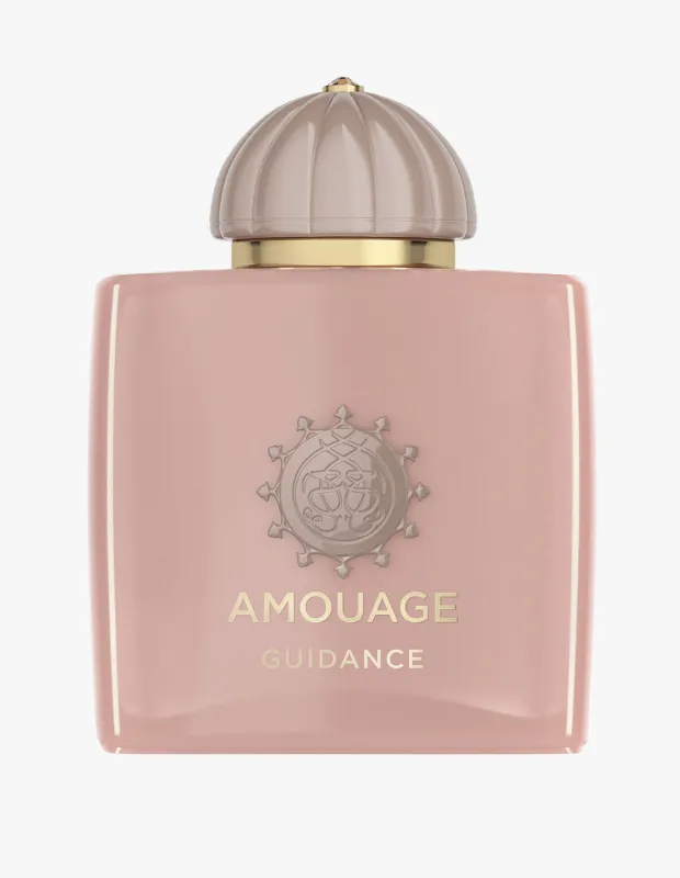 Amouage Guidance parfüm şişesi, markanın imzası olan zarif kabartmalı logosuyla süslenmiş, soluk pembe rengindeki dikdörtgen gövdesi ve yivli bej kubbe kapağının altın detaylarıyla modern ve çekici bir tasarıma sahip.