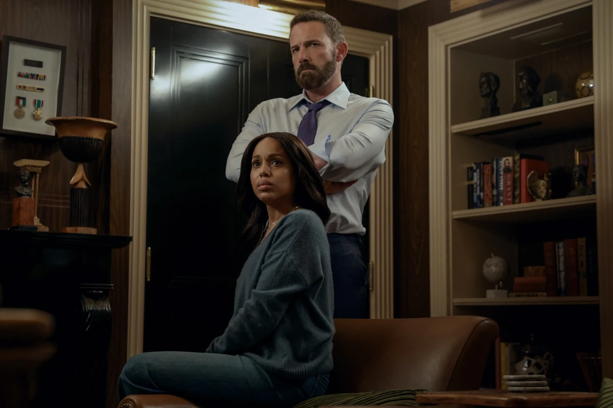 Netflix yapımı bir filmden bir sahne: Şık döşenmiş bir odada Ben Affleck, kollarını kavuşturmuş ciddi bir ifadeyle ayakta dururken, Kerry Washington endişeli bir bakışla deri bir koltukta oturuyor, ikili arasındaki gergin atmosfer belirgin.