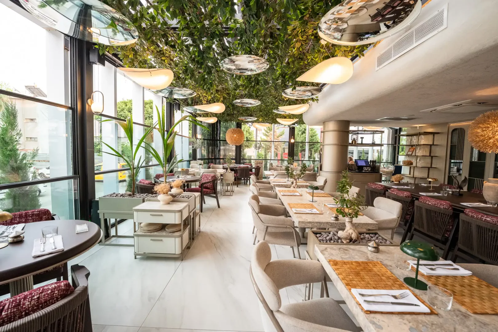 Antalya'da yeni nesil restoranlar arasında öne çıkan 4 KÖŞE RESTAURANT'ın, modern Akdeniz mutfağının ruhunu yansıtan, doğal bitki örtüsüyle süslü tavanı, çağdaş aydınlatmaları ve uzun sofralarıyla davetkar bir gastronomi deneyimi sunan şık iç mekanı.