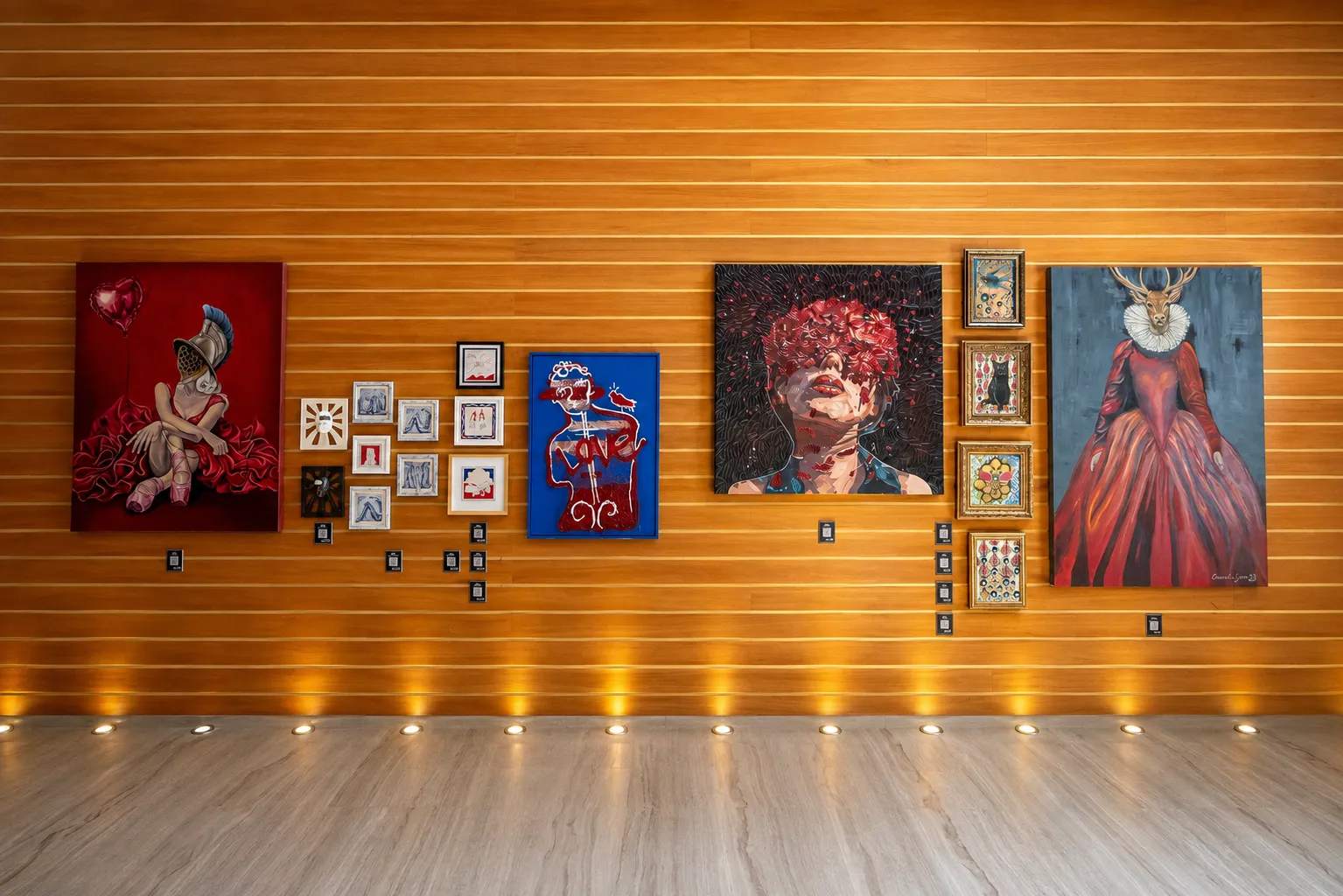 Kızıl ahşap panellerle kaplı bir duvarda, zeminden yükselen ışıklarla aydınlatılmış modern bir sanat sergisi atmosferinde, gladyatör kasklı bir kadından geyik başlı bir figüre ve soyut kompozisyonlara uzanan çeşitli boyutlarda resimler QR kodları eşliğinde dikkat çekiyor.