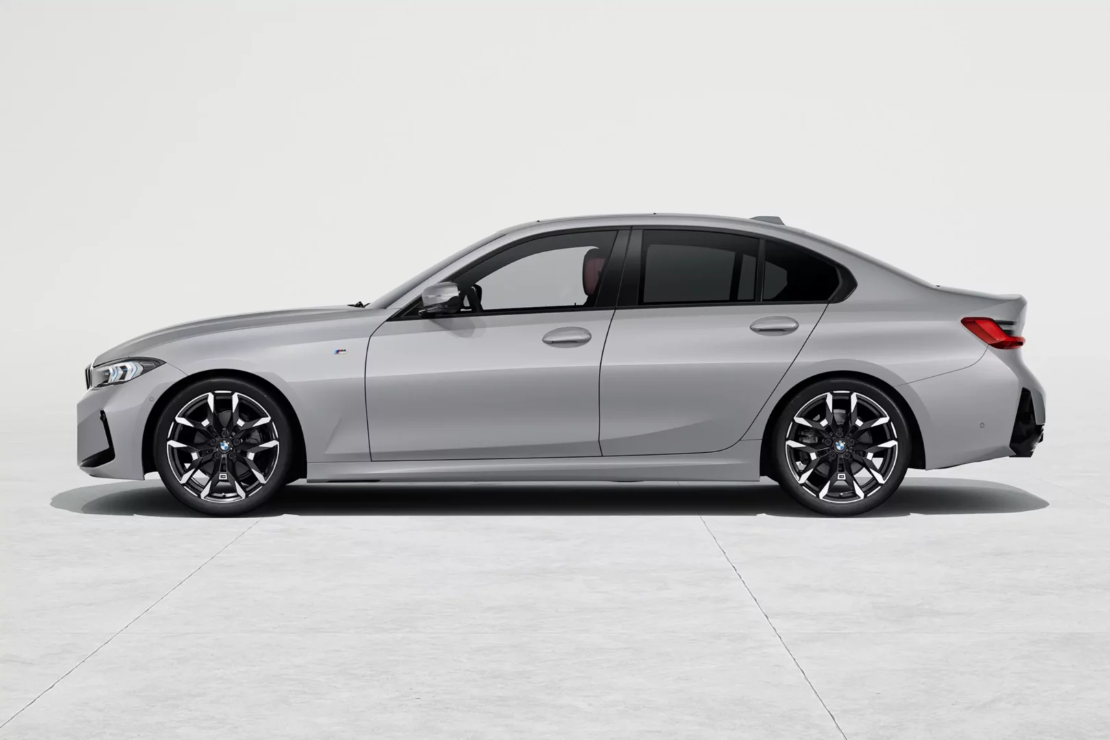 Yan profilden çekilmiş, açık gri renkte, şık tasarımlı bir BMW 3 Sedan otomobil beyaz stüdyo fonunda duruyor, modern siyah çok kollu jantları ve M Sport detayıyla dinamik görünümünü sergiliyor.