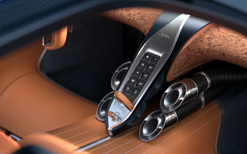 Bugatti Derstrier hiper otomobilin lüks iç mekan tasarımında, kahverengi deri kaplı orta konsol üzerinde Solitaire yazılı metal kontrol paneli ve yanlarda dikkat çekici krom görünümlü havalandırma çıkışları detaylı bir şekilde gösteriliyor.