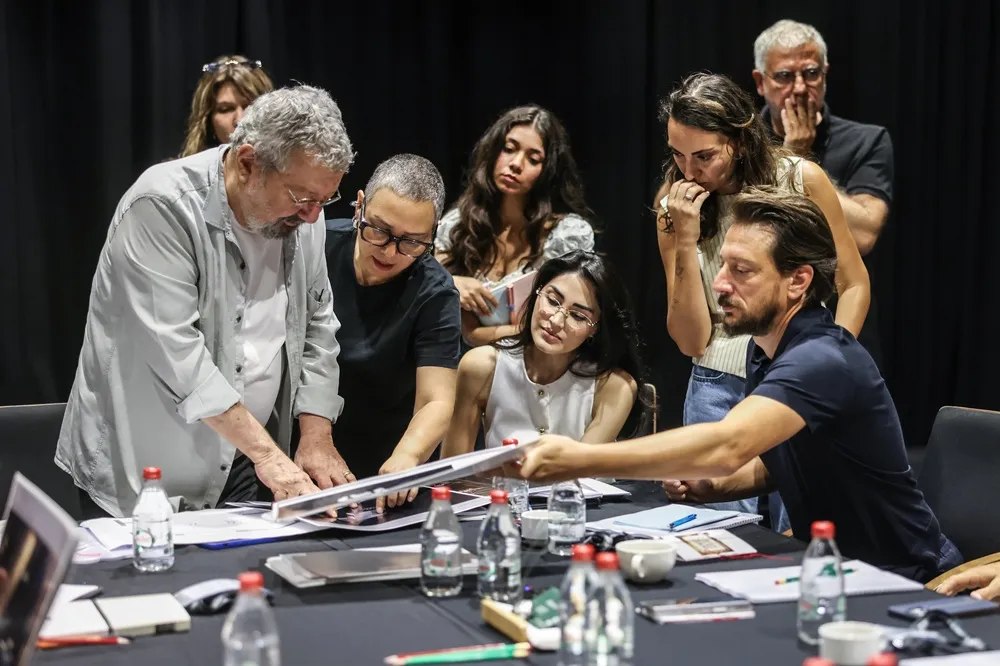 Zorlu PSM'de sahnelenecek Dorian Gray'in Portresi tiyatro oyununun yönetmeni Mehmet Birkiye ve yaratıcı ekibi, masanın etrafında toplanmış, oyunun dekor, kostüm ve sahne tasarımı detaylarını yoğun bir şekilde inceleyerek hazırlık sürecinin önemli bir anını paylaşıyor.