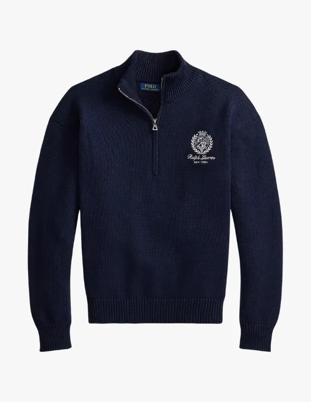 Lacivert tonlarında, yüksek dik yakaya sahip, önünde gümüş rengi çeyrek fermuar detaylı ve sol göğsünde beyaz işlemeli Ralph Lauren arması ile NEW YORK yazısı bulunan, ribanalı manşetleri ve etek ucuyla şık bir görünüm sunan bu erkek sweatshirt, rahatlığı ve modern çizgiyi bir araya getiriyor.