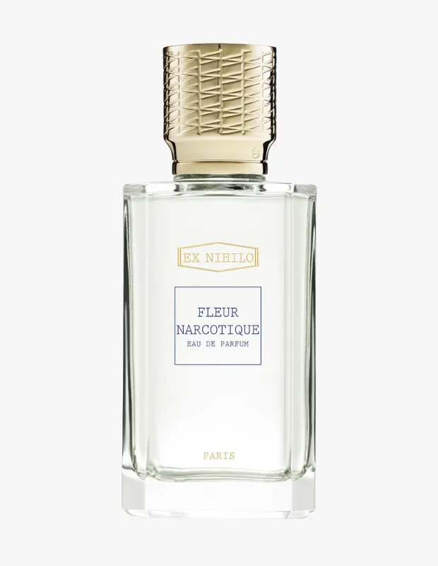 EX NIHILO Fleur Narcotique Eau de Parfum adlı şeffaf, dikdörtgen cam şişenin altın renkli, dokulu kapağıyla birlikte beyaz bir zeminde duruşunu gösteren bu fotoğraf, markanın zarif ürün tasarımını ve Paris imzalı yüksek kaliteli parfümünü vurgulamaktadır.