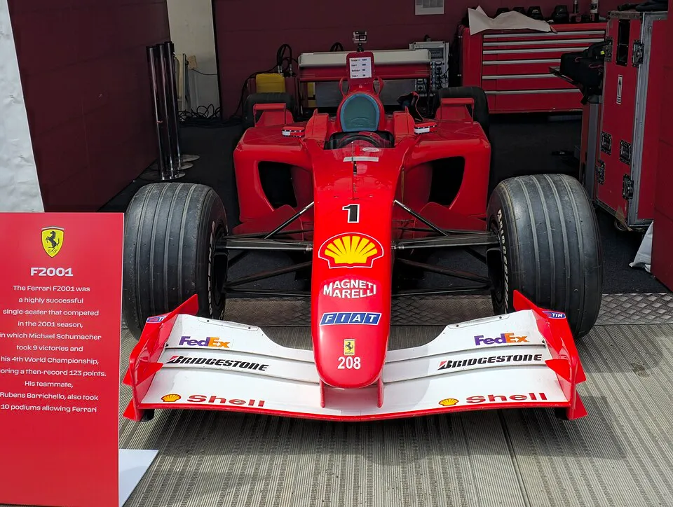 Kırmızı renkli, Michael Schumacher'in 2001 Dünya Şampiyonası'nda kullandığı ünlü Ferrari F2001 Formula 1 aracı, ön kanadında FedEx ve Bridgestone, burnunda Shell ve Magneti Marelli logoları ile 1 numarası belirgin şekilde görülerek bir sergi alanında sergileniyor.