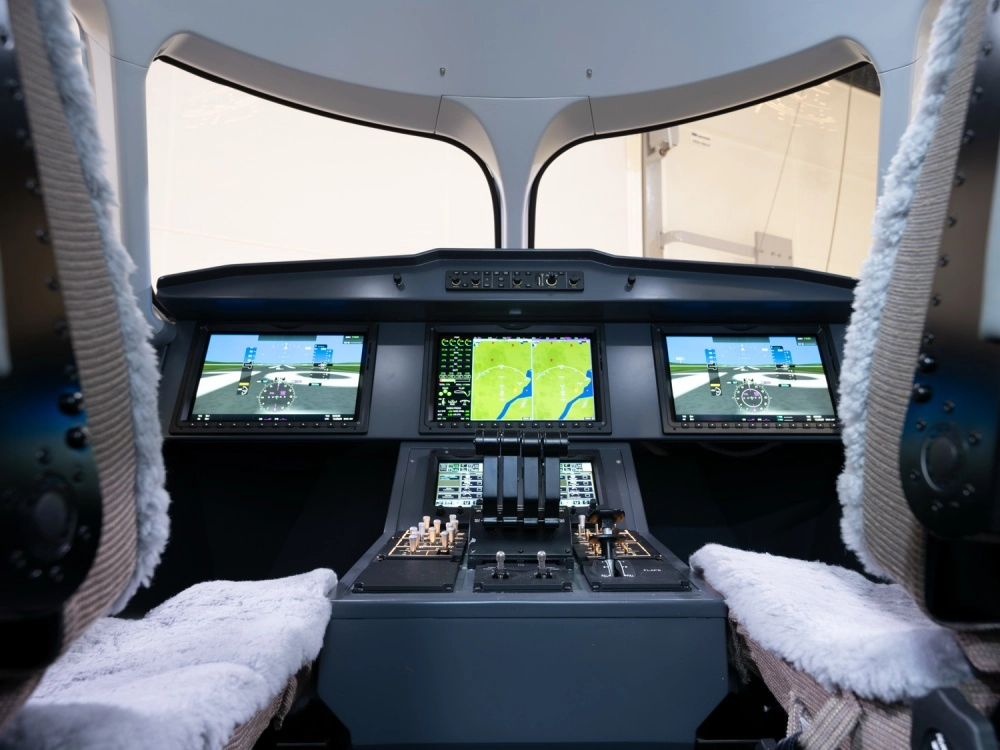 Bill Gates'in de yatırım yaptığı dünyanın en büyük elektrikli uçağı Heart Aerospace X1'in kokpitinde, uçuş ve navigasyon bilgilerini gösteren üç büyük dijital ekran, altında modern kontrol panelleri ve gaz kolları yer alıyor, bu da onun son teknoloji bir test platformu olma özelliğini vurguluyor.
