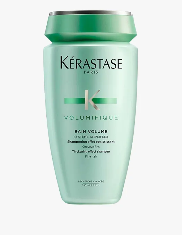 Açık mint yeşili renkte, üst kısmı koyu yeşil ve gümüş detaylı kapaklı Kerastase markasının Volumifique serisinden, özellikle ince telli saçlara hacim ve dolgunluk katmak üzere tasarlanmış 250 ml'lik bir hacim şampuanı şişesi beyaz bir arka plan üzerinde dikkat çekici şekilde duruyor.