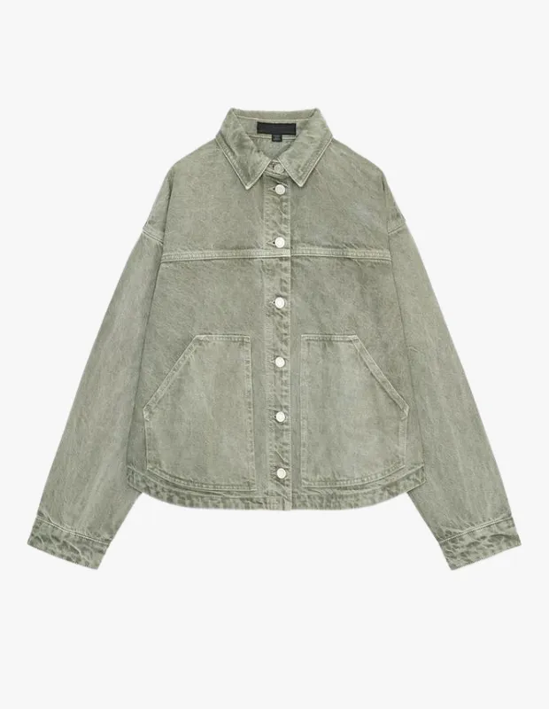 Beyaz bir arka plan üzerinde sergilenen, soluk haki yeşili renginde, yıkanmış görünümlü denim kumaşından yapılmış, önü parlak beyaz düğmeli, yakalı ve iki geniş yama cepli, modern ve oversize kesimli bir kot ceket.