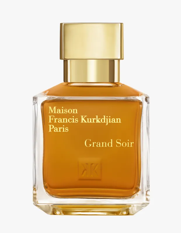 Beyaz arka plan üzerinde zarifçe konumlandırılmış, altın sarısı rengindeki içeriği şeffaf cam şişesinde parlayan ve parlak altın kapağa sahip Maison Francis Kurkdjian Paris Grand Soir parfümü, şişenin ön yüzünde marka adı ve logosuyla birlikte şık bir duruş sergiliyor.
