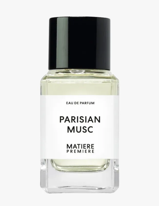 Beyaz arka plan önünde, şeffaf camdan yapılmış, mat siyah kapaklı Matiere Premiere Parisian Musc Eau de Parfum şişesi; içinde hafif sarımsı yeşil renkte sıvı, ortasında büyük harflerle PARISIAN MUSC yazan beyaz etiket ile ürünün şıklığını vurguluyor.