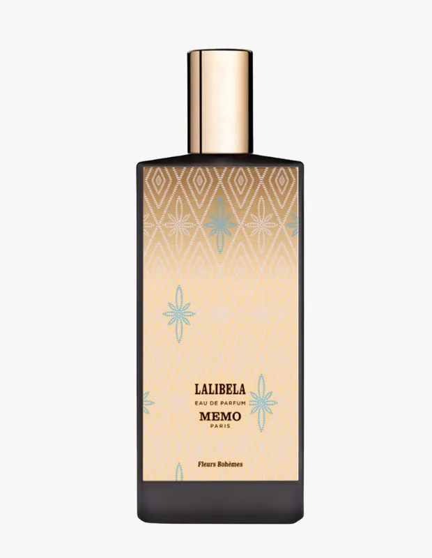 Koyu renk tabanı ve parlak altın kapaklı, Memo Paris Lalibela Eau de Parfum şişesi, krem ve bej tonlarındaki etiketinde zarif elmas ve açık turkuaz yıldız desenleriyle, parfümün çiçeksi ve bohem ruhunu yansıtan sofistike bir tasarıma sahip.