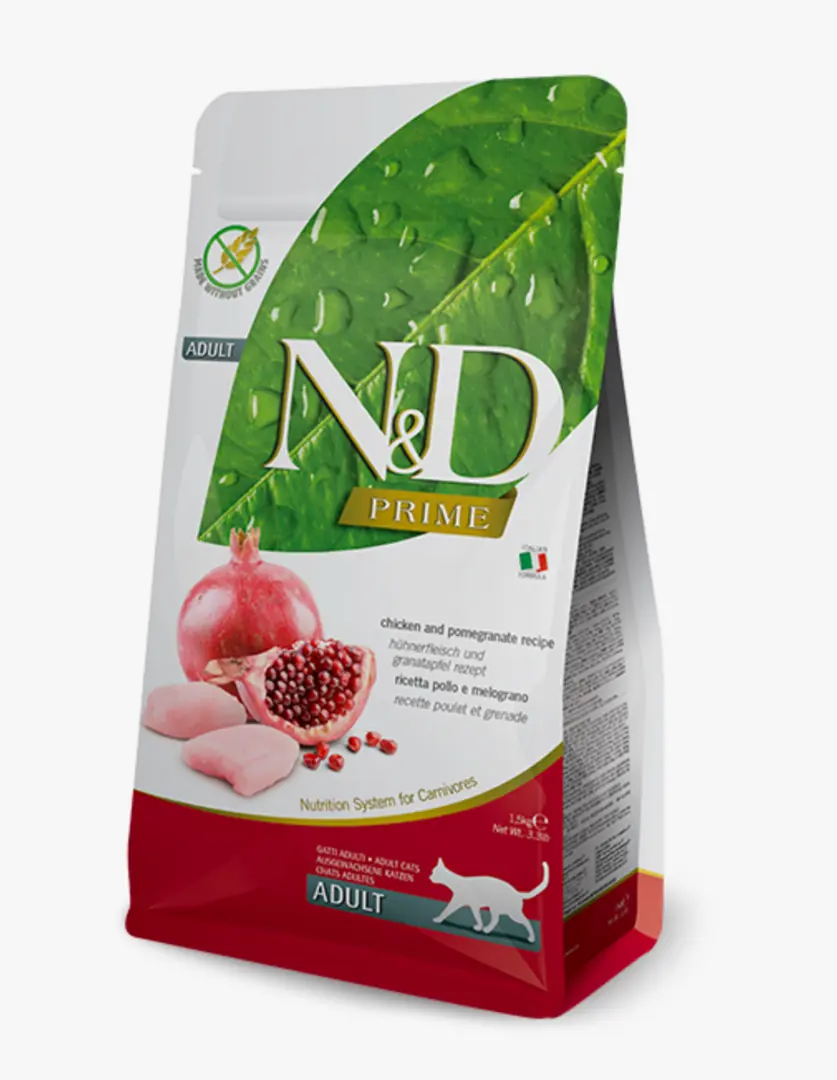N&D Prime markalı, sulu yeşil bir yaprağın önünde bütün ve yarım nar ile tavuk etleri gösteren, kırmızı ve beyaz tasarımlı, tahılsız olduğu belirtilen, 1.5 kg'lık yetişkin kedi maması paketi, karnivorlar için özel beslenme sistemini vurgulamaktadır.
