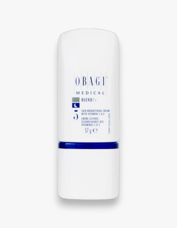 Dik olarak konumlandırılmış, beyaz renkli Obagi Medical Nu-Derm Blend fx cilt aydınlatıcı krem şişesi, ortasındaki parlak mavi şerit detayı ve üzerinde C & E vitaminleri içeren 57 gramlık ürünü belirten yazılarıyla sunulmaktadır.