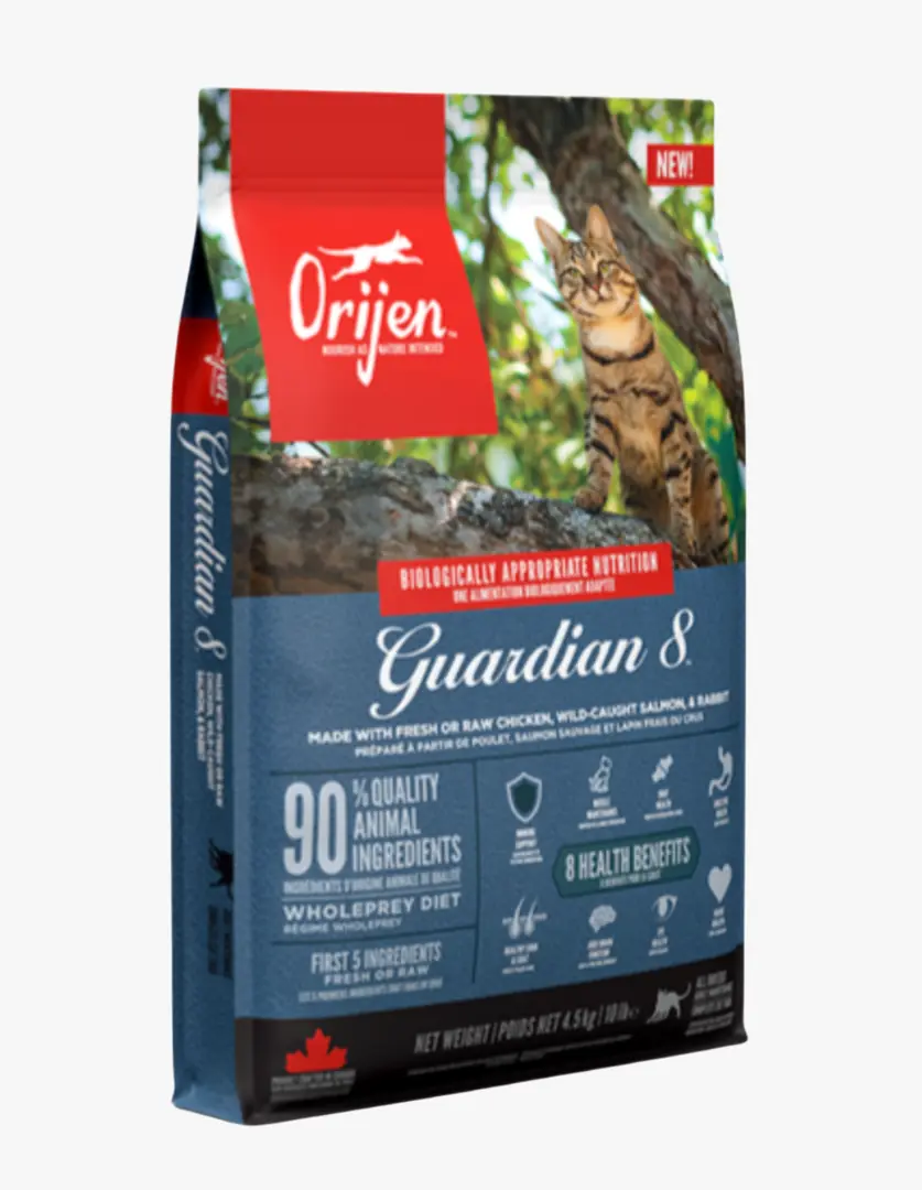 Kırmızı ve lacivert renklerdeki Orijen Guardian 8 kedi maması paketi, üzerinde oturan bir tekir kedinin ve arka plandaki ağaç dallarının görseliyle dikkat çekerken, ürünün yüzde doksan kaliteli hayvansal içerik ve sekiz sağlık faydası sunduğu bilgileriyle, patili dostlar için besleyici bir seçenek olduğunu sergiliyor.