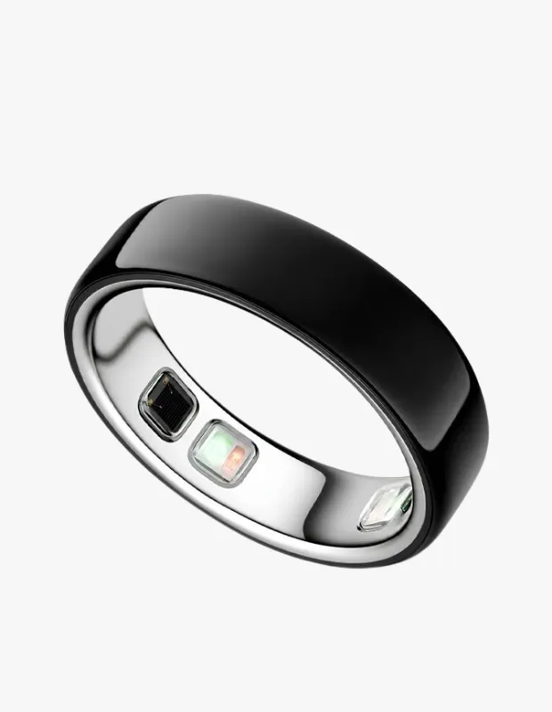 Parlak siyah dış yüzeye ve iç kısmında kalp atış hızı, uyku ve aktivite takibi gibi özellikler sunan gelişmiş biyometrik sensörlere sahip, minimalist tasarımlı bir Oura akıllı yüzük, ışık yansımasıyla beyaz bir zeminde zarifçe duruyor.