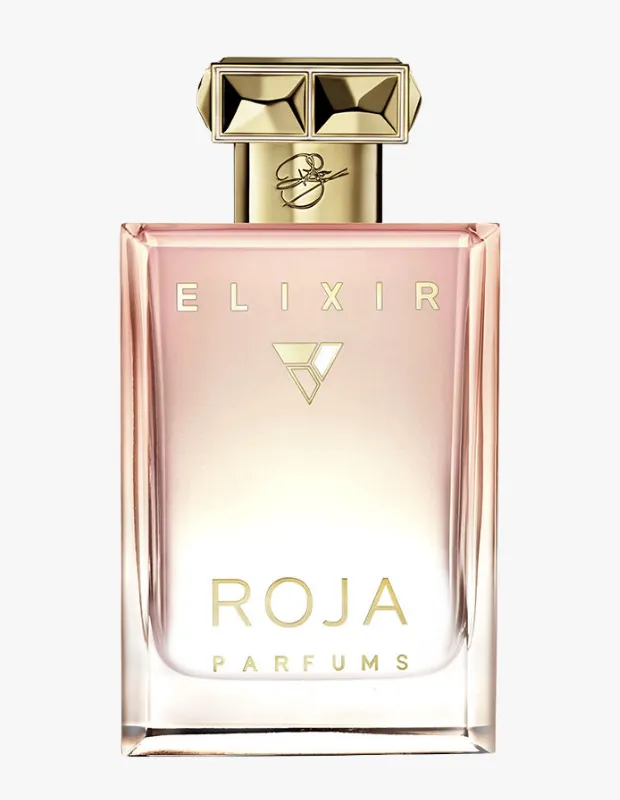 Sade beyaz bir zemin üzerinde sergilenen, pembe-altın yansımalı şeffaf camdan yapılmış, içindeki Elixir parfüm sıvısının rengini vurgulayan, altın rengi, mücevher benzeri detaylara sahip kapağı ve ön yüzünde zarif altın harflerle yazılmış ROJA PARFUMS markasını taşıyan lüks bir parfüm şişesi.