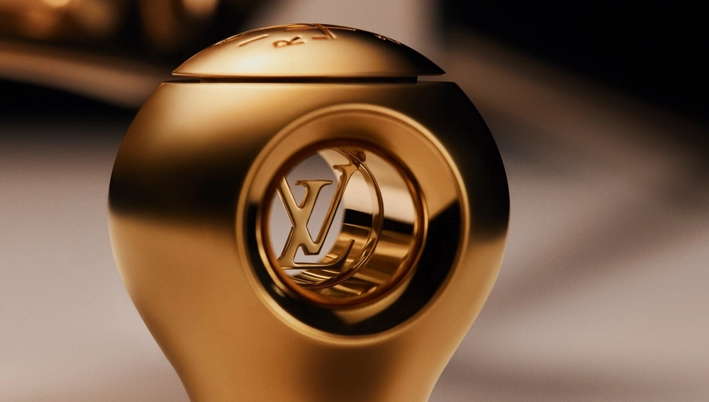 Altın rengi lüks bir vites topuzu, merkezinde zarifçe işlenmiş Louis Vuitton logosu ve üst yüzeyinde Singer yazısıyla, Singer ve Louis Vuitton iş birliğinin Porsche 911 restomod koleksiyonuna özel olarak tasarlanmış, bu özel iş birliğini vurgulayan bir detayı sergiliyor.