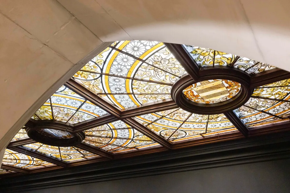 Stanley Park'ın zengin iç dekorasyonunun bir parçası olan bu vitray tavan, sarı ve beyaz tonlarında detaylı çiçek motifleri ve ortasında arma bulunan dairesel panellerle süslü, ahşap çerçeveli zarif bir sanat eseridir.