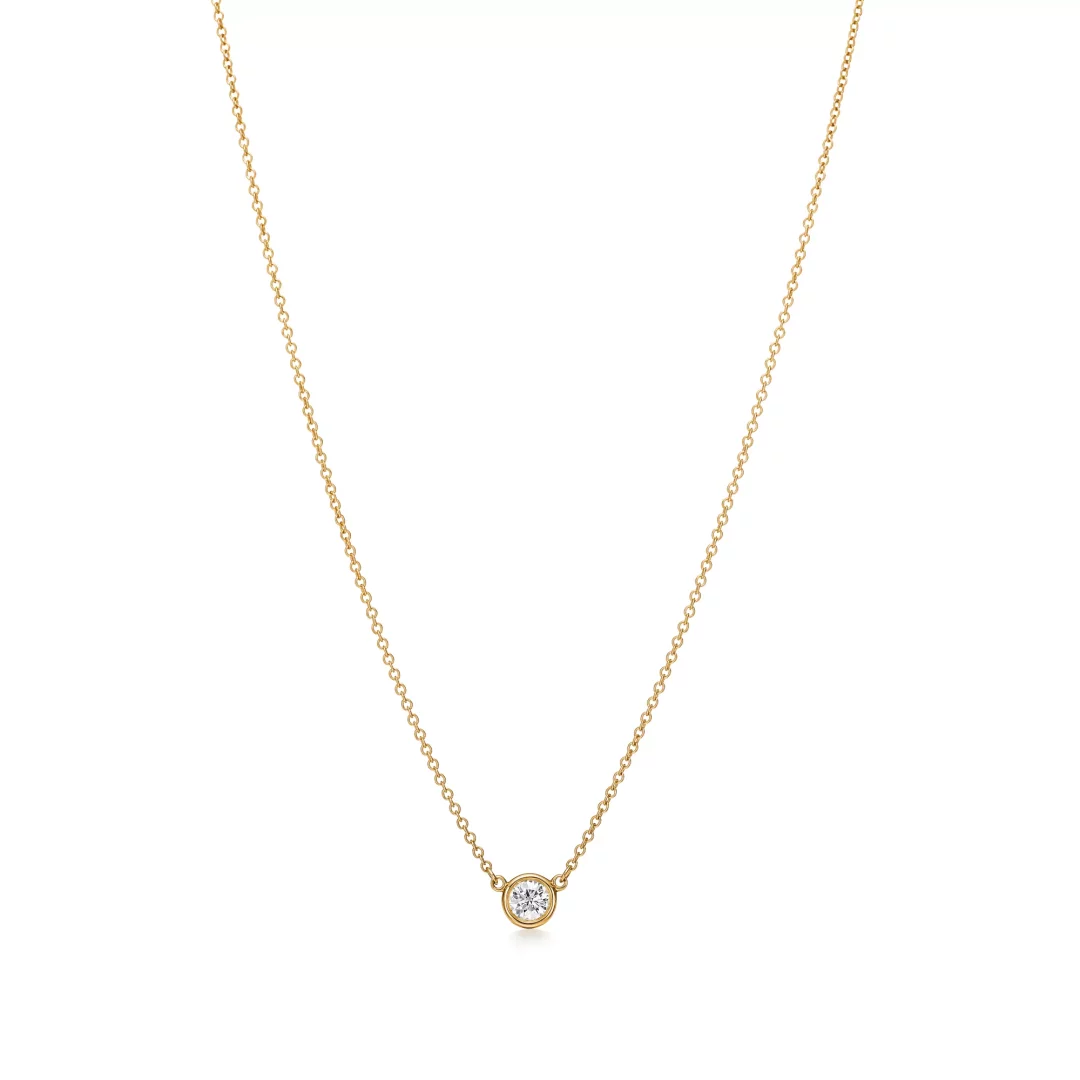 Beyaz arka plan üzerinde zarifçe sergilenen, ince altın zincire kusursuzca oturtulmuş, ışıl ışıl yuvarlak kesim tek bir pırlantayla dikkat çeken bu şık Tiffany Diamonds by the Yard kolyesi.