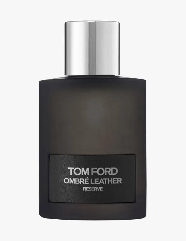 Parlak gümüş renkli silindirik kapağı ve mat siyah dikdörtgen şişesiyle Tom Ford Ombré Leather Reserve parfümü, üzerinde ürün adının yazılı olduğu koyu renkli bir etiketle beyaz fon önünde sergileniyor.