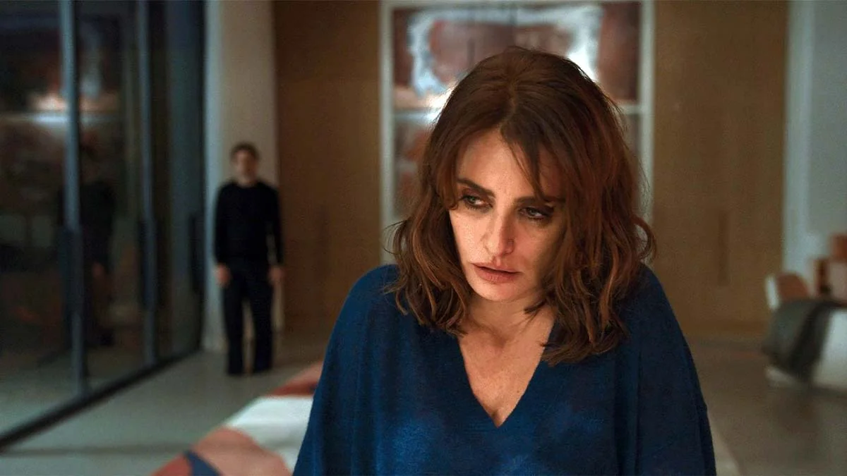 Venedik Film Festivali'nin Altın Aslan için yarışan filmlerinden Bunker'dan bir sahne, modern bir iç mekanda, önde koyu mavi bluzlu, endişeli yüz ifadesiyle aşağıya bakan Penélope Cruz'u ve bulanık bir şekilde arkasında duran Javier Bardem'i gösteriyor.