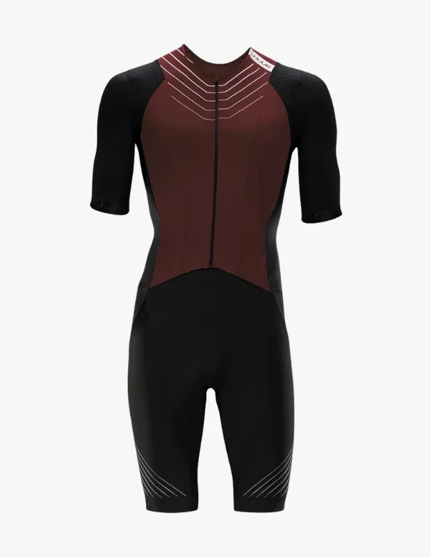 Beyaz bir arka plan üzerinde sergilenen, üst kısmı bordo, kolları ve alt kısmı siyah renklerde tasarlanmış, önden fermuarlı, kısa kollu ve diz hizasında şortlu bir trisuit görseli. Göğüs kısmındaki beyaz ok benzeri çizgiler ve bacaklardaki paralel desenler dikkat çekiyor; bu modern yüzücü mayosu, triatlon yarışları için aerodinamik performans sunar.