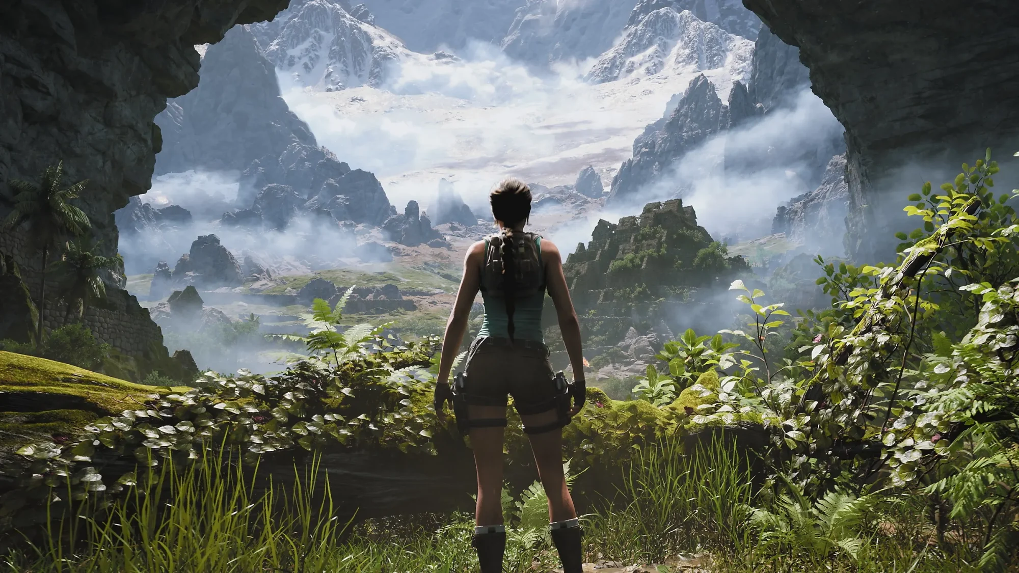 Bir mağara ağzından, sırtı dönük, sırt çantalı Tomb Raider karakteri Lara Croft, önündeki sisli, karlarla kaplı dağların ve antik tapınak kalıntılarının göründüğü yemyeşil, uçsuz bucaksız bir vadiye bakıyor; bu görüntü 2027 oyunları evreninden bir kesit sunuyor olabilir.