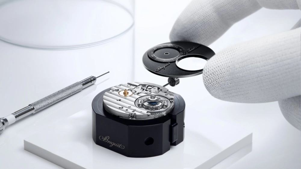 Gökyüzü haritası temalı lacivert mineli kadranı üzerinde karmaşık tourbillon mekanizması ve yıldız göstergeleri ile dikkat çeken, zarif detaylara sahip platin kasalı Breguet Classique Tourbillon Sideral lüks saatinin büyüleyici yakın çekim görüntüsü.