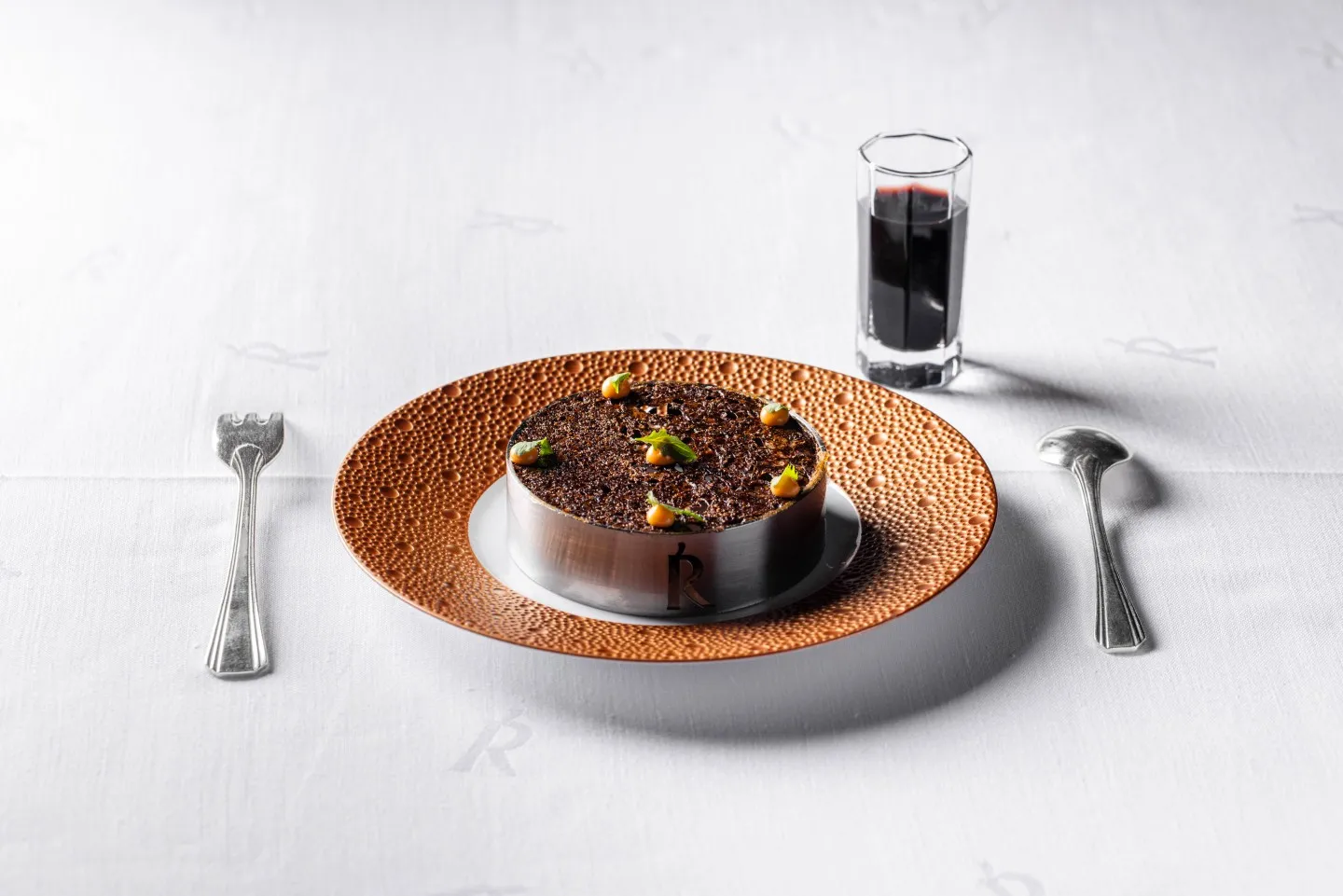 Akelarre Restoran'ın zarif aydınlatmaları ve minimalist tasarımıyla dikkat çeken, misafirlerine eşsiz bir yemek deneyimi sunan geniş ve modern iç mekanı, masaların özenle düzenlendiği sakin bir anı yansıtmaktadır.