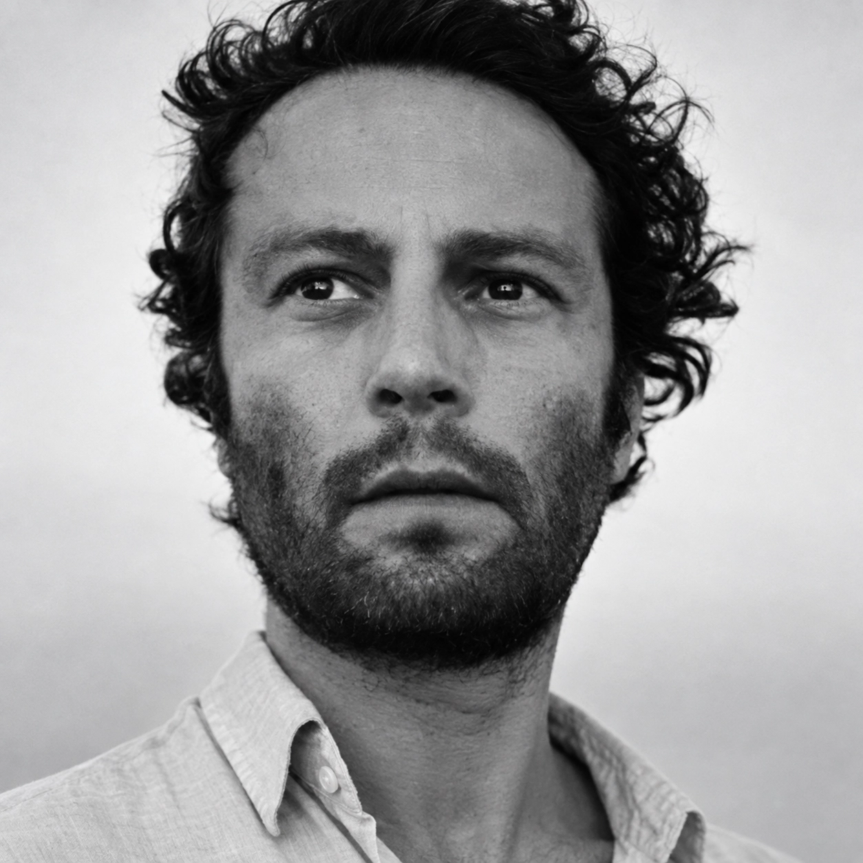 Fotoğrafçı Arslan Sükan'ın, 212 Photography Istanbul festivalinde Uzun Baktıkça Değişen Görüntüler temalı bakış açısını anlattığı yazısında, koyu renk blazer ceketi ve açık renk gömleğiyle, sakin bir ifadeyle doğrudan objektife bakarken çekilmiş profesyonel portre fotoğrafı.