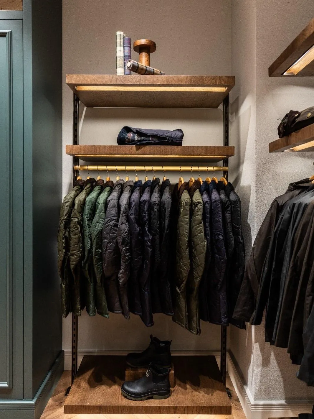 Zengin miras ve güncel stilin buluştuğu Barbour Tersane mağazasında, doğal tonlardaki ikonik wax ceketler, çeşitli tamamlayıcı aksesuarlar ve kaliteli kıyafetler sıcak ahşap raflarda ve modern standlarda özenle sergilenerek markanın zamansız kalitesini ve farklı kuşaklara hitap eden yaşam tarzını etkileyici bir şekilde yansıtıyor.