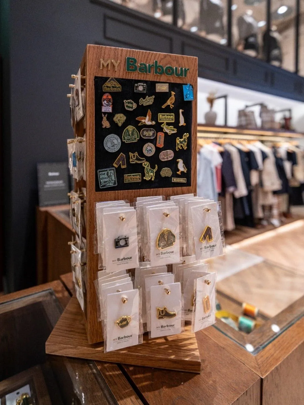 Türkiye'deki Tersane İstanbul Barbour mağazasının içinde, ahşap raflarda sergilenen ve markanın 132 yıllık mirasından gelen ikonik wax ceketlerin doğal tonları, zamansız stilini ve kaliteli işçiliğini vurgulayarak markanın güncel ve premium yaşam tarzı duruşunu yansıtıyor.